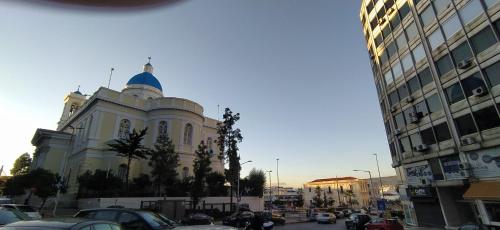 a large building with a blue dome on a city street at ΜΕ ΘΕΑ ΤΟ ΛΙΜΑΝΙ in Piraeus