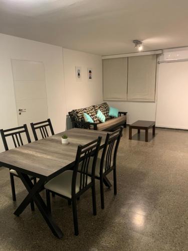 Habitación con mesa, sillas y sofá en Alto Colon Mendoza en Mendoza