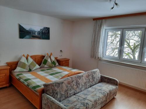 ein Wohnzimmer mit einem Sofa und einem Bett in der Unterkunft Bauernhof-Laimerhof in Bad Aussee