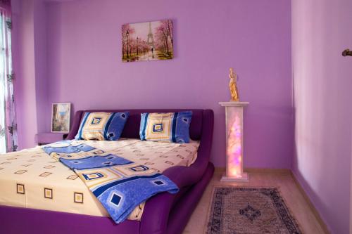 a bedroom with purple walls and a bed at Summer by the sea in Paralia Katerinis