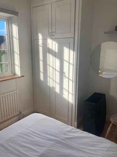 1 dormitorio con cama blanca y ventana en Entire Terraced two story redbrick house with parking in secluded cul de sac en Dublín
