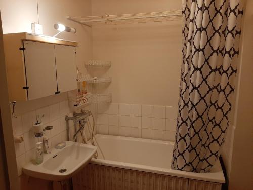 a bathroom with a sink and a tub and a shower curtain at Апартаменты в Иматре in Imatra