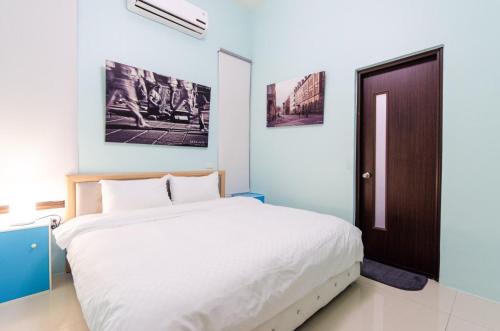 a bedroom with a white bed and a brown door at Touch 星空包棟民宿寵物友善民宿 in Wujie