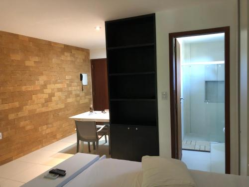 um quarto com uma cama e uma casa de banho com uma mesa em Villas do Pratagy - Pitanga B3 em Maceió