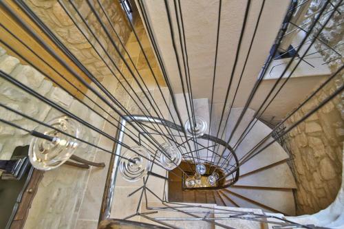 a spiral staircase with a chandelier in a building at La Maison du Passage - Chambres - Suites premium, Spa, Piscine et Restaurant in Martignargues