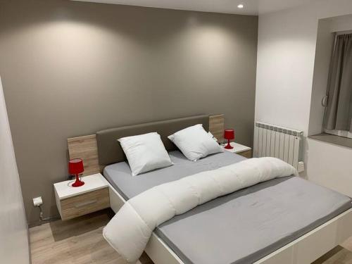Un dormitorio con una cama con dos velas rojas. en Appartement neuf, au coeur du massif Vosgien, en Fraize
