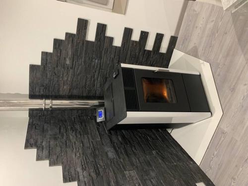 un salon avec une cheminée sur le mur dans l'établissement Appartement neuf, au coeur du massif Vosgien, à Fraize