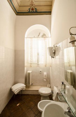 a white bathroom with a toilet and a sink at Hotel Iris in Perugia