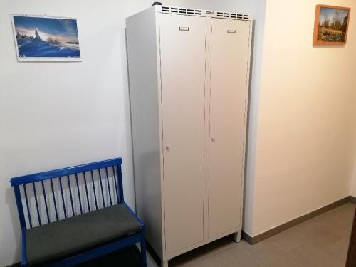 a white cabinet and a chair in a room at Apartmány Na náměstí in Boží Dar