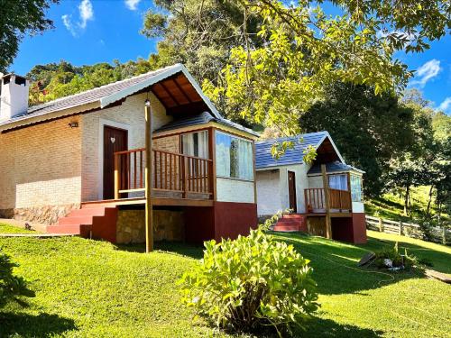 a small house with a porch and a balcony at Estalagem da Montanha in Monte Verde