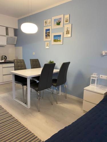 a dining room with a white table and chairs at Apartament Nautica Pogorzelica in Pogorzelica