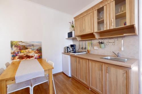 a kitchen with wooden cabinets and a wooden table at ECO-LUX APART with free bicycles end free parking in Ljubljana