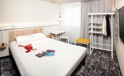 Habitación de hotel con cama y estante en ibis Pontarlier, en Pontarlier