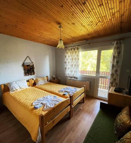 sypialnia z dwoma łóżkami i drewnianym sufitem w obiekcie Villa Diva w mieście Apriłci