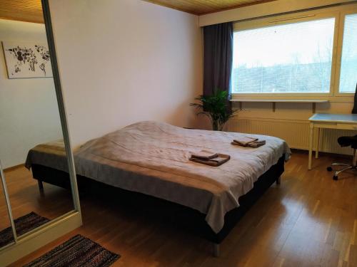 a bedroom with a bed and a large mirror at Kaukajärven Joutsen - valoisa ja tilava kaksio in Tampere