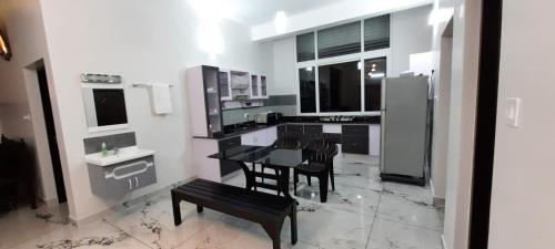 a kitchen with a black table and chairs and a counter at V HOMES Vagamon in Vagamon