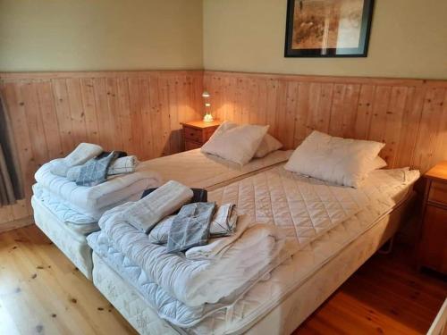 two large beds in a room with wooden walls at Sjötorp säteri & stugby in Larv