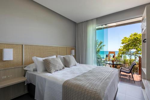 a bedroom with a bed and a view of the ocean at Pousada Gaúcha in Bombinhas