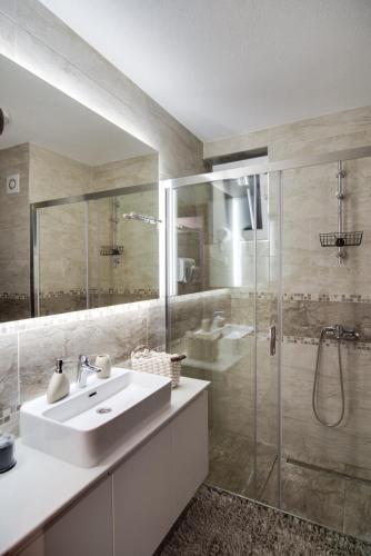 a bathroom with a sink and a glass shower at IN LUX SPA APARTMAN in Vrnjačka Banja