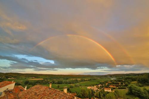 a double rainbow in the sky over a town at La Maison du Passage - Chambres - Suites premium, Spa, Piscine et Restaurant in Martignargues