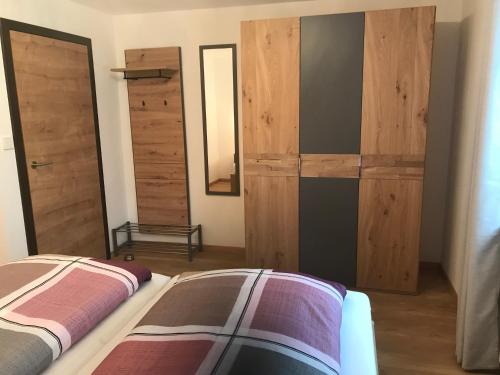 a bedroom with wooden sliding doors and a bed at Ferienwohnung Falkenstein in Rettenberg