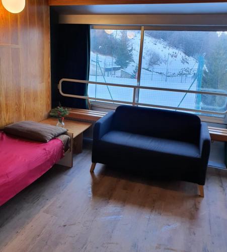 a living room with a couch and a large window at Marilleva 1400 tra sport e natura in Marilleva