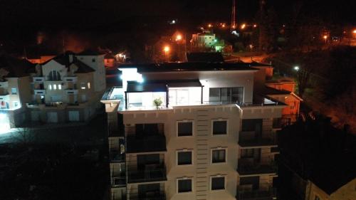 a white apartment building at night with lights at IN LUX SPA APARTMAN in Vrnjačka Banja