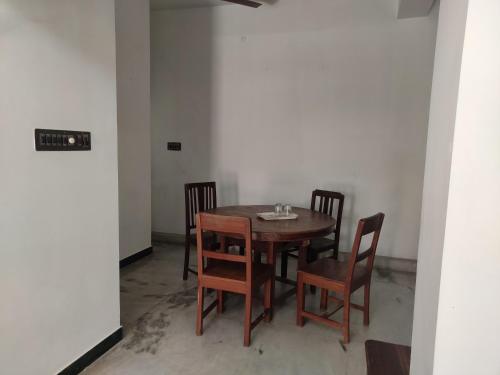 una mesa de madera y sillas en una habitación en Villa Souhayl homestay, en Pondicherry