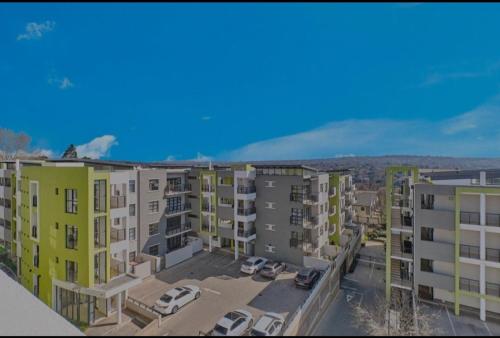 uma vista aérea de um complexo de apartamentos com carros estacionados em Modern One Bedroom Apartment in Rivonia em Joanesburgo