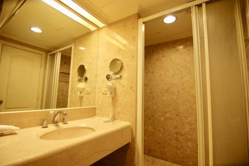 a bathroom with a sink and a shower with a mirror at 台中自由行 in Taichung