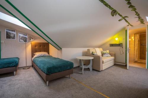 un dormitorio con una cama y un sofá en DOMINO - pokoje i apartamenty, en Szklarska Poręba