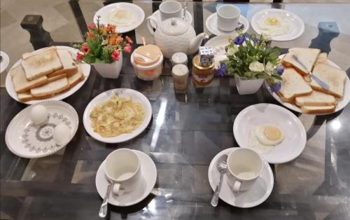 a table topped with white plates and bowls of food at Hotel Seven 7 in Karachi
