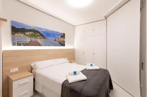 sypialnia z 2 łóżkami i obrazem na ścianie w obiekcie Karmengo Ama baskeyrentals w mieście San Sebastián