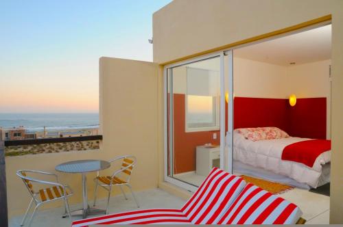 um quarto com uma cama, uma mesa e cadeiras em Terrazas de la Viuda em Punta Del Diablo