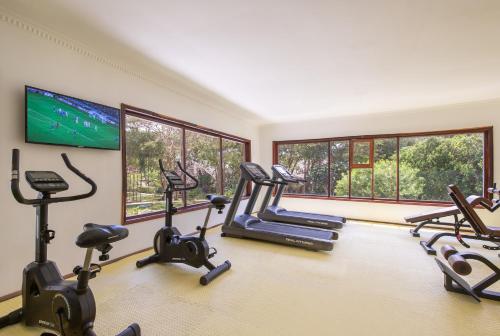 a gym with cardio machines and a flat screen tv at Kiwengwa Beach Resort in Kiwengwa