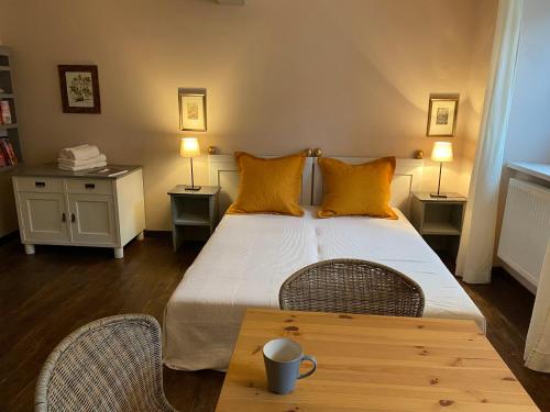 a bedroom with a bed with yellow pillows and a table at Apartmány Rudík in Železná Ruda