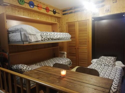 a room with two bunk beds and a table with a candle at APARTAMENTO LOS VALLES en SIERRA NEVADA Parking gratuito in Sierra Nevada