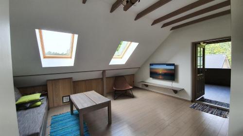 a living room with a tv and a table at Sea House Dzelmes in Mazirbe