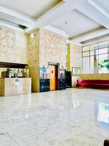 a lobby with a red couch in a building at Alvorada Palace Hotel de Poços in Poços de Caldas