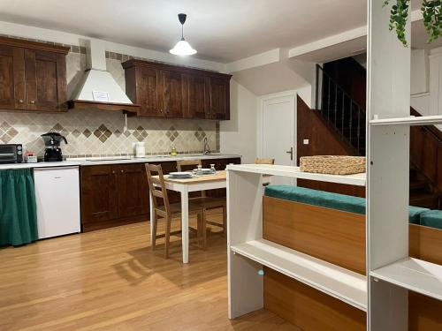 una cocina con armarios de madera y una mesa con sillas. en Lety's House, en Civita Castellana