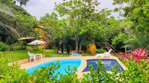 ein Bild eines Swimmingpools in einem Garten in der Unterkunft Loft Reserva Sapiranga Praia do Forte Vila Hen 102 in Mata de Sao Joao