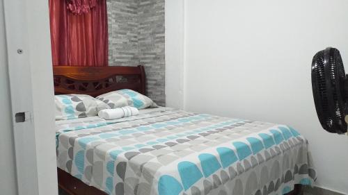 a bedroom with a bed with a blue and white blanket at Apartamento como en casa in Soledad