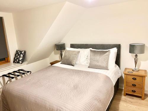 a bedroom with a large white bed with two lamps at Waterloo Townhouse Inverness in Inverness