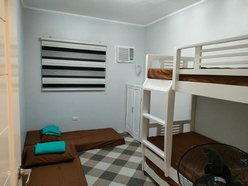Zimmer mit 2 Etagenbetten und einem Schreibtisch in der Unterkunft Lucky Swiss Transient House Alaminos - Entire House near Hundred Islands in Bolo