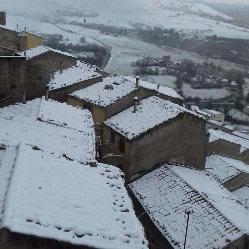 a village covered in snow with roofs at La Nicchia di Gangi in Gangi