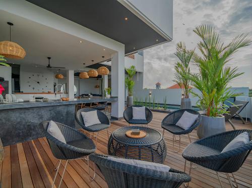 a patio with chairs and a table and a kitchen at Villa Mimpi Bali in Jimbaran