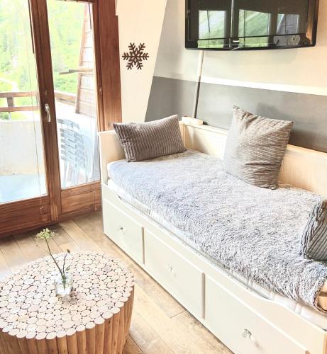 un banc blanc avec une table dans une pièce dans l'établissement Penthouse Apartment 28m² in Avoriaz right next to 3 ski lifts, lake view, à Avoriaz