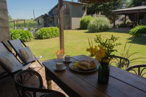 a wooden table with a plate of food on it at Refugio En Las Sierras in Tandil