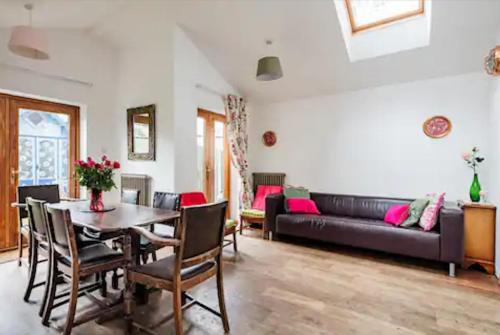 ロンドンにあるLovely Three Bedroomed House, Parking 2 Carsの黒いソファとテーブルのあるリビングルーム