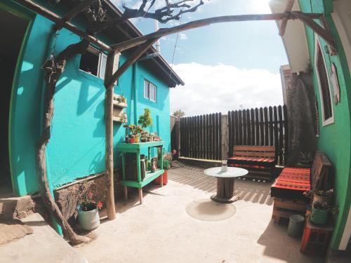 a patio with a blue house and a table at Los Rukos Cabanas (Bungalows) in Pichilemu